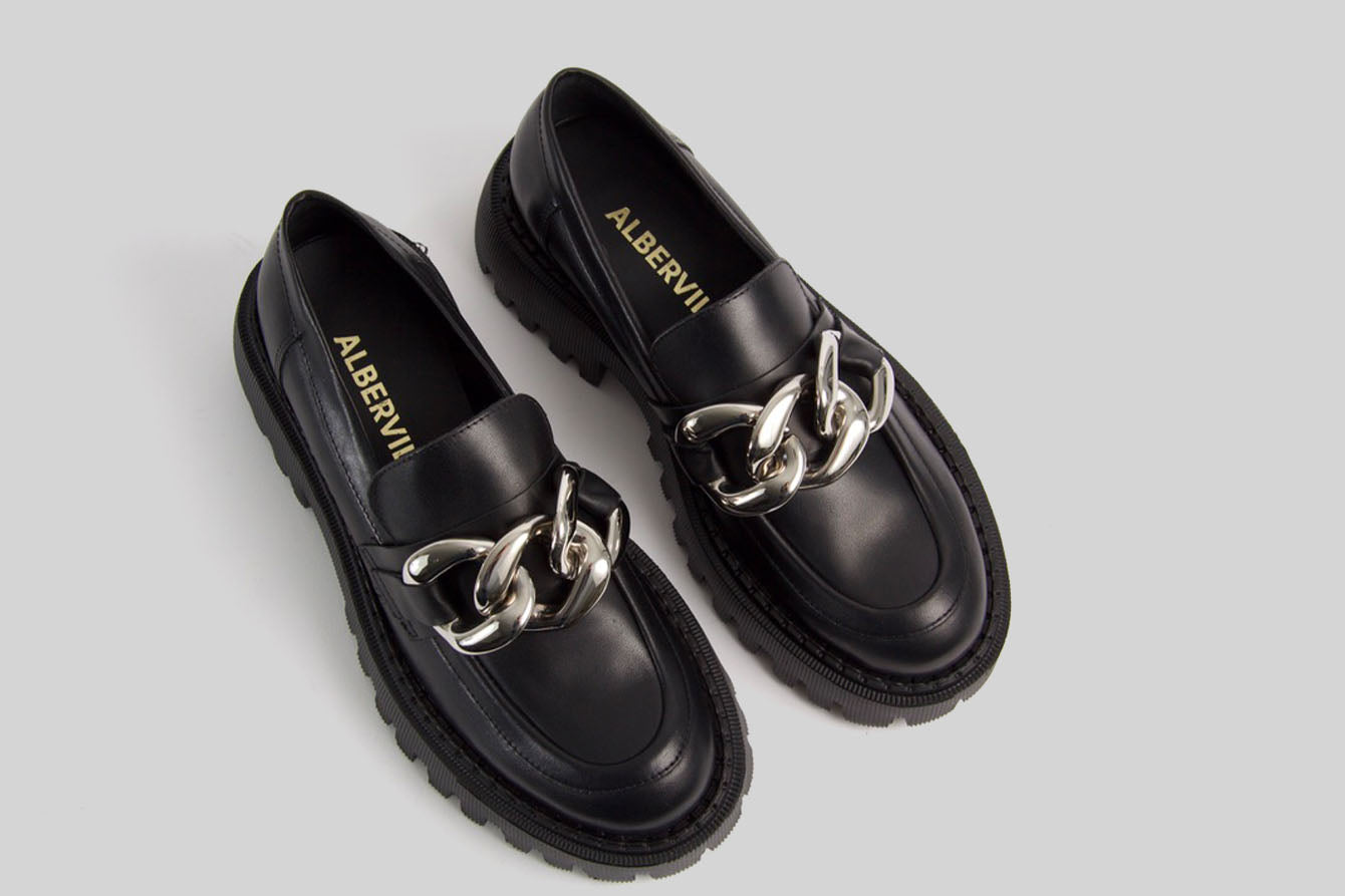 Black loafer with a golden chain.