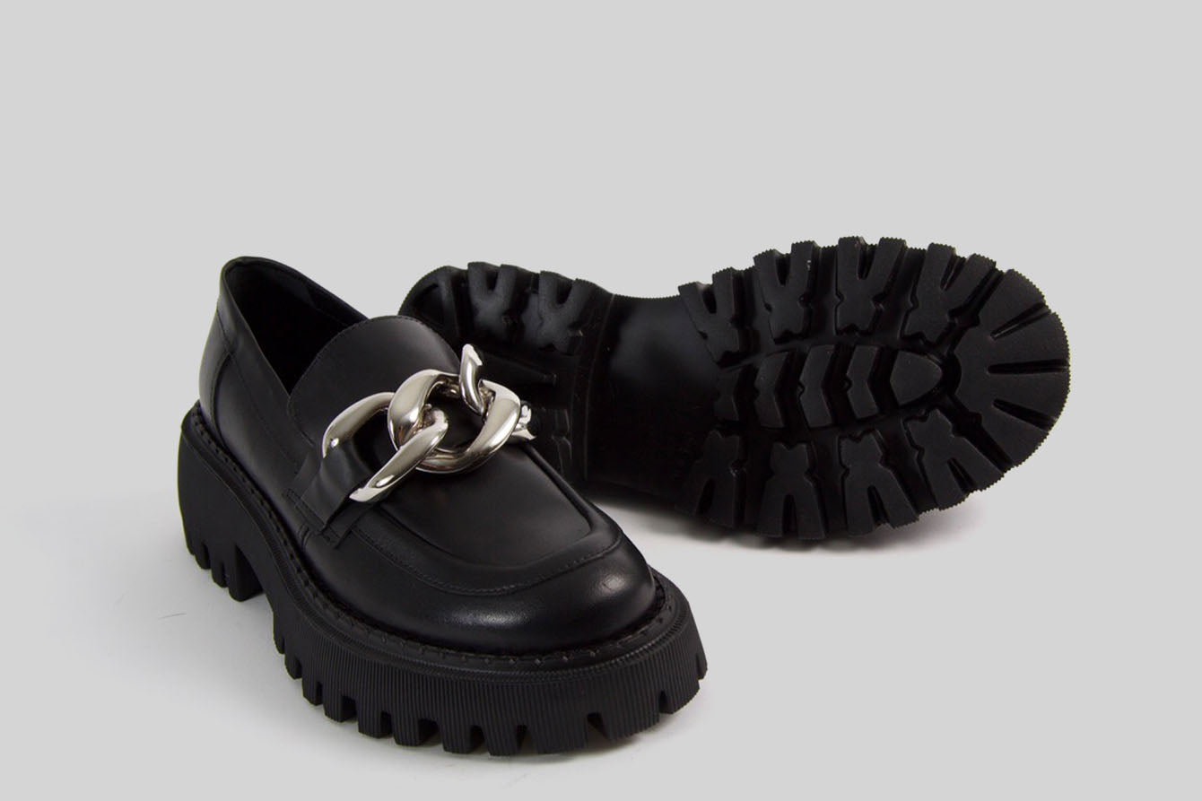 Black loafer with a golden chain.