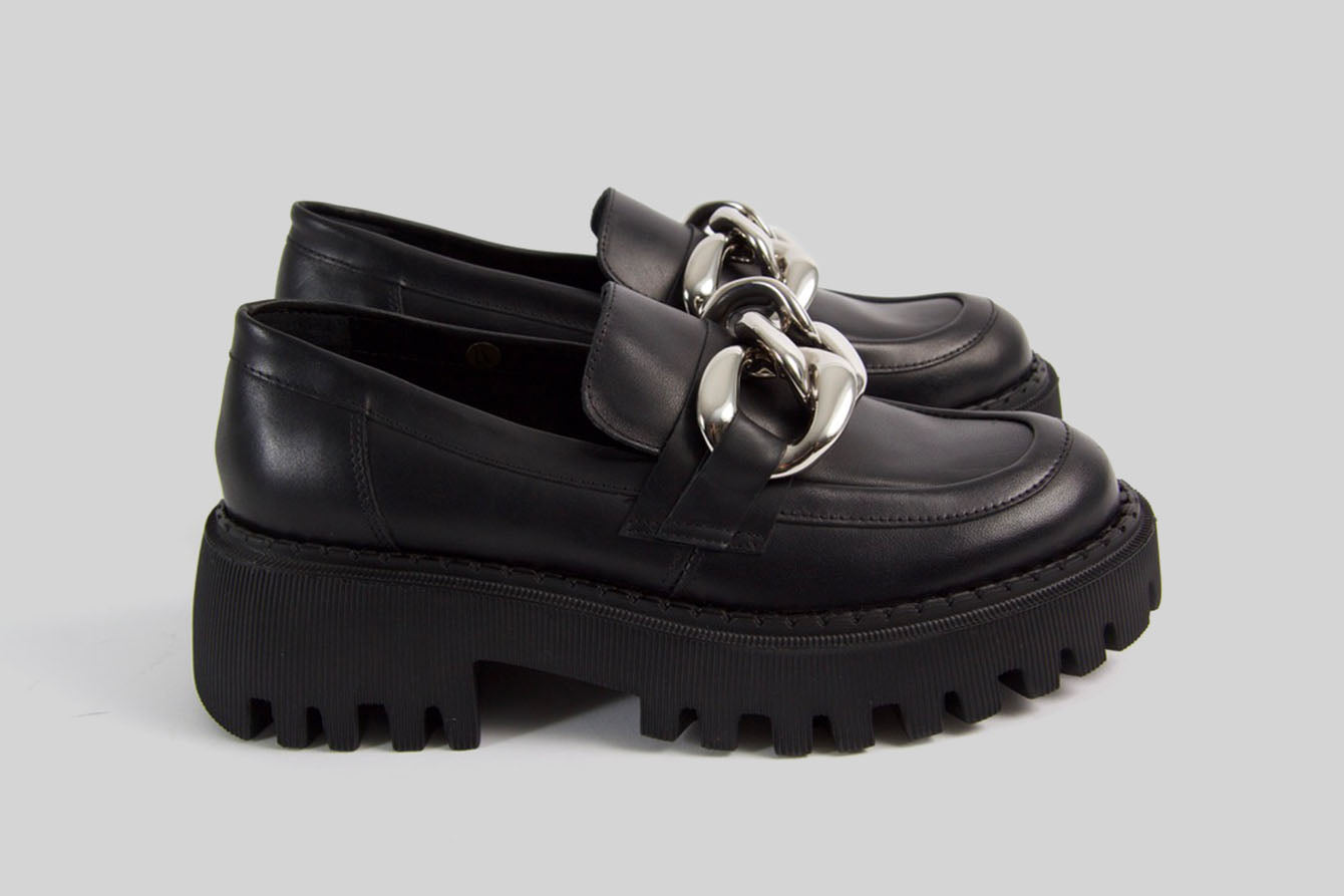 Black loafer with a golden chain.