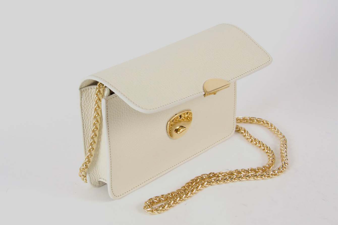Small offwhite handbag with a golden strap.